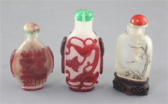 Three Chinese glass snuff bottles, late 19th / early 20th century, 5.6cm excl. wood stand